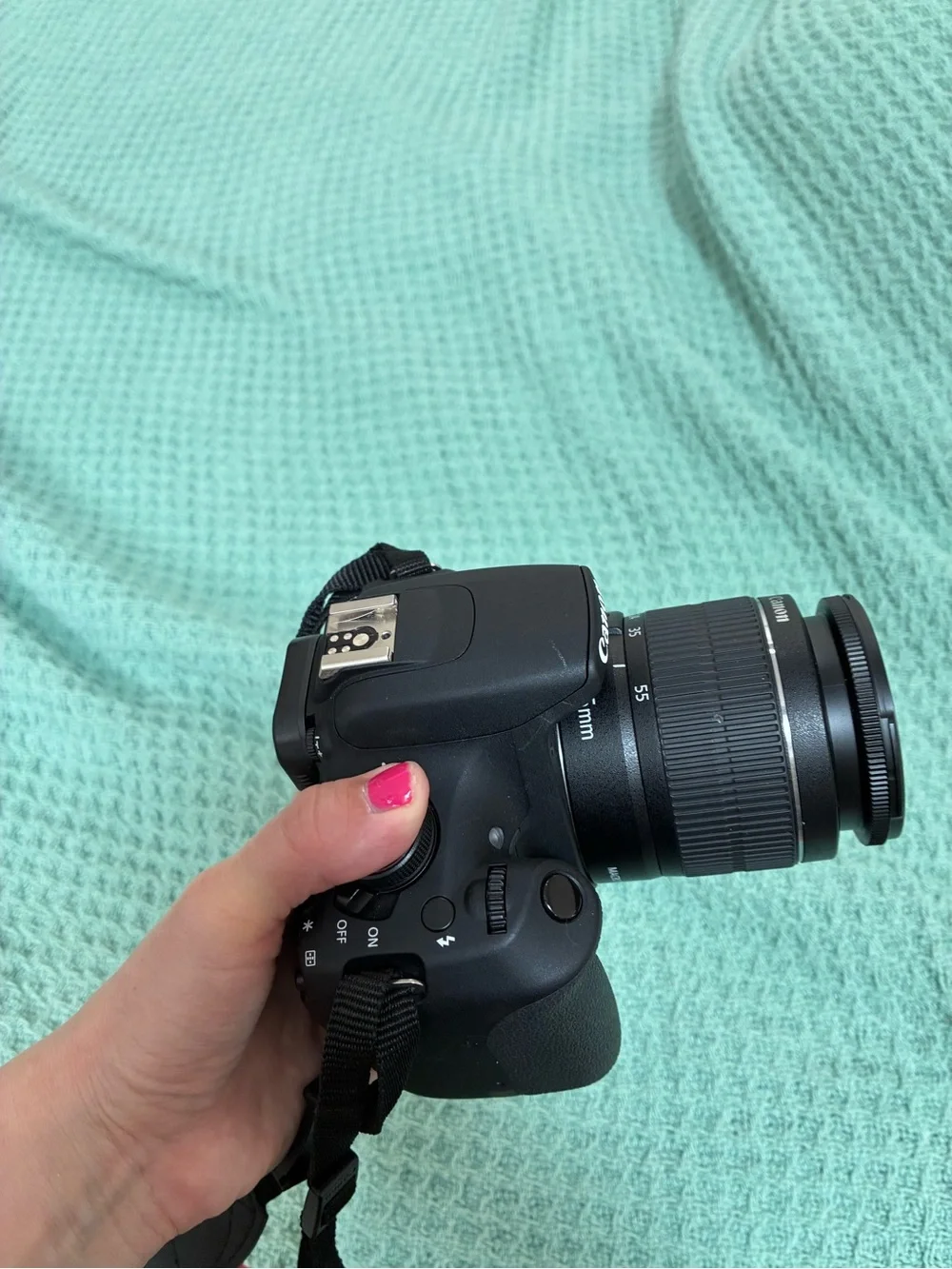 Canon DSLR Camera Body in Black with Red Strap Accents and kit lens.